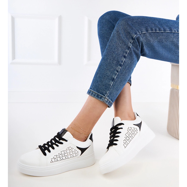 Weiße Turnschuhe mit schwarzen Einsätzen auf der Plattform 2