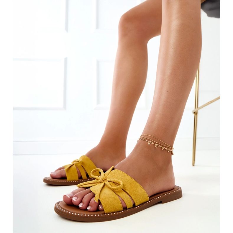 Gelbe Flip flops mit Bug und Dekoration an den Rändern 1