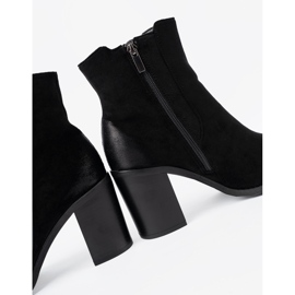 Shelvt Schwarze Wildlederstiefel auf einer hohen Säule isoliert 1