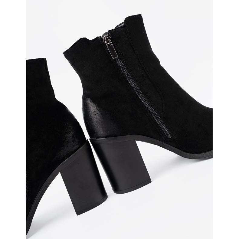 Shelvt Schwarze Wildlederstiefel auf einer hohen Säule isoliert 1