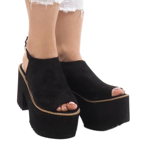 Schwarze Sandalen auf einem massiven B8290 Block 1