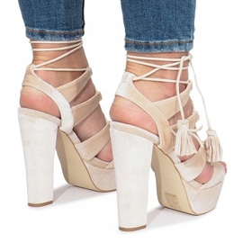 Graue Sandalen auf einem One Love Veloursposten 1