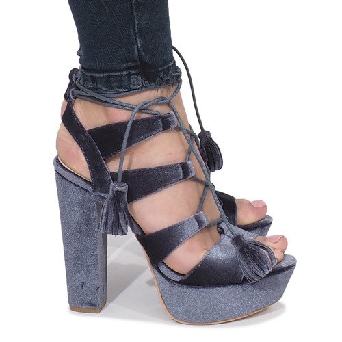 Graue Sandalen auf einem One Love Veloursposten 1