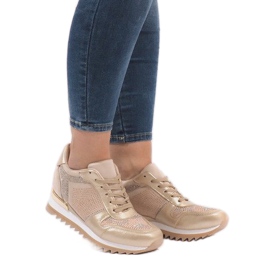 Goldene Turnschuhe auf dem Keil G-125 1