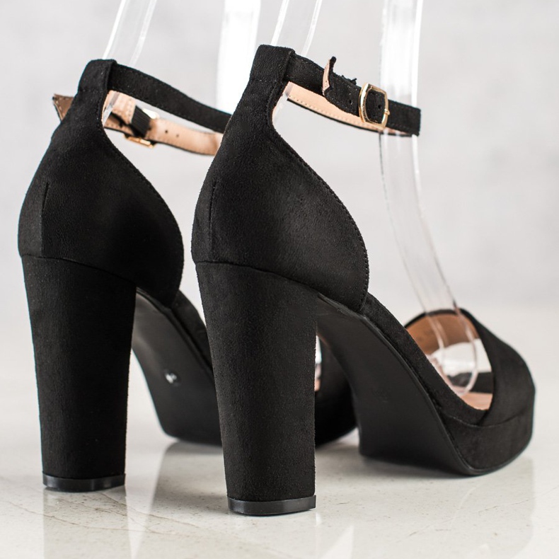 Weide Schwarze Sandalen auf einer Bar 1