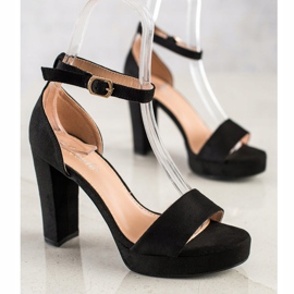 Weide Schwarze Sandalen auf einer Bar 2