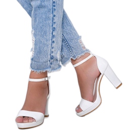 Weiße Sandalen an einem Pfosten mit einem Black Rose-Ledermuster 1