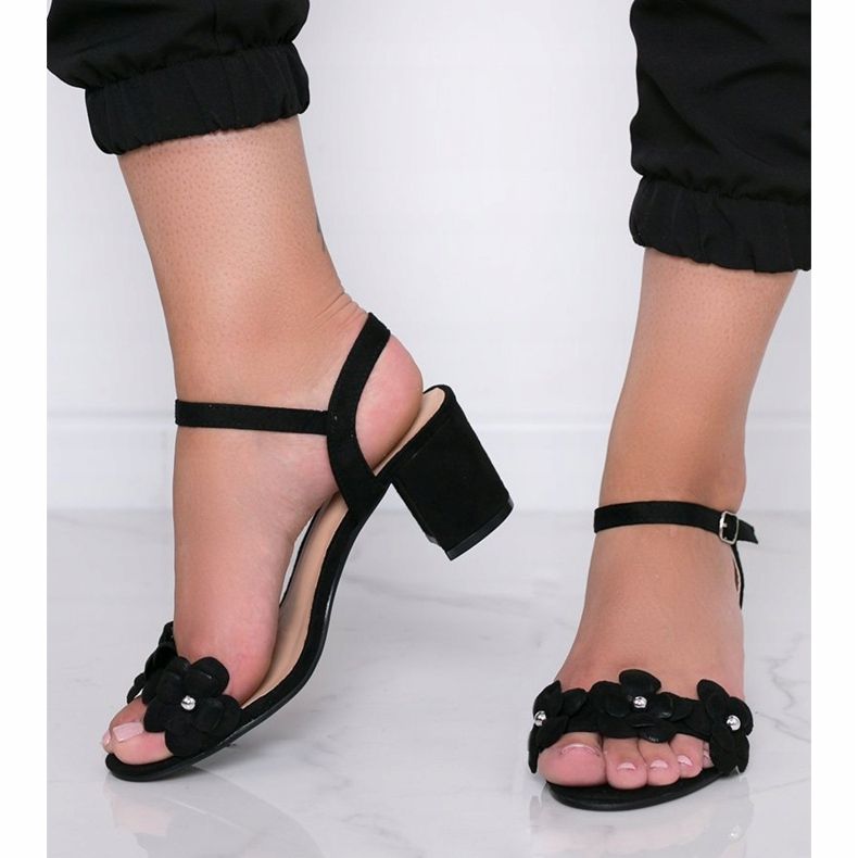 Schwarze Sandalen auf einem Pfosten mit Little Havana Blumen 1