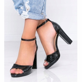 Schwarze Sandalen an einem Pfosten mit Millo Schlangenledermuster 2