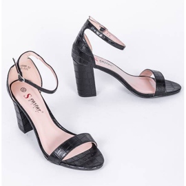 Schwarze Sandalen am Millo-Pfosten 1