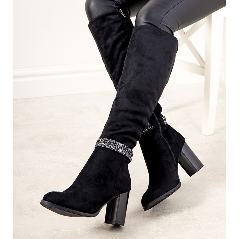 Schwarze Stiefel auf dem Pfosten von isoliertem Alexis 1