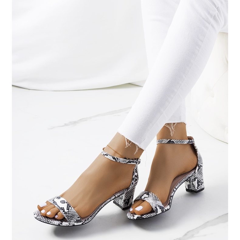 Weiße Sandalen an einem Pfosten mit dem Azevedo-Schlangenmotiv 1