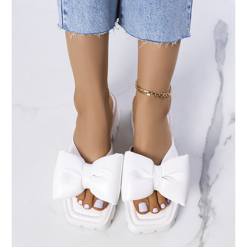 Weiße Pantoffeln auf der Traktorsohle des Platt 1