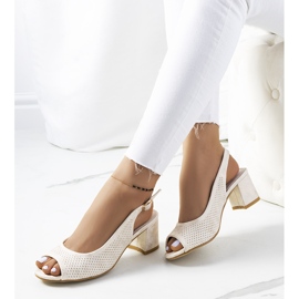 Goldene durchbrochene Sandalen an einem Malone-Pfosten 1